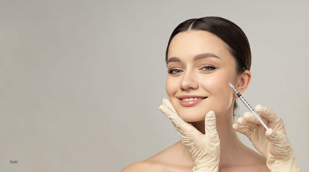 Gloved hands administer an injection into a woman's face